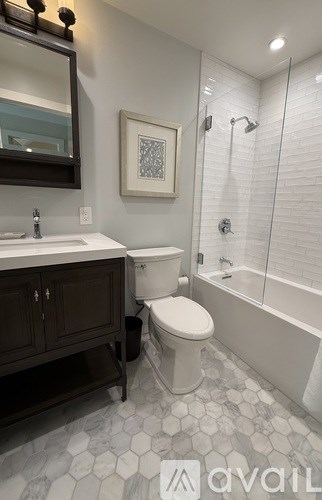 A white toilet sits in a bathroom with a white tiled floor.