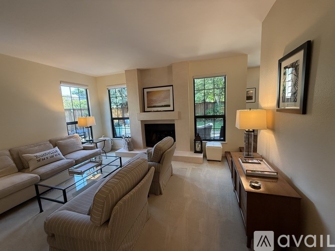 A living room with a couch, a chair, a coffee table, and a fireplace.