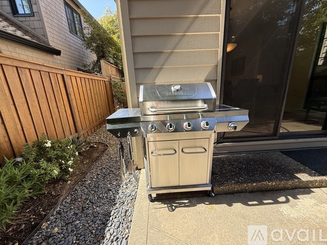 A Weber grill is on a patio outside a house.
