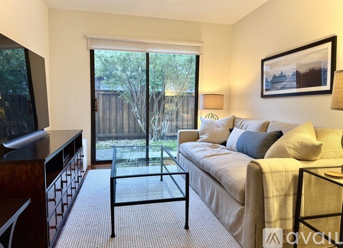 A living room with a couch, a coffee table, and a television.