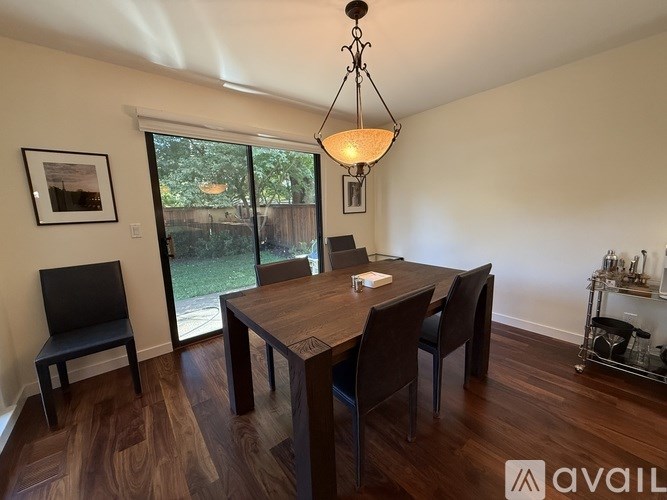 A dining room with a wooden table and chairs.