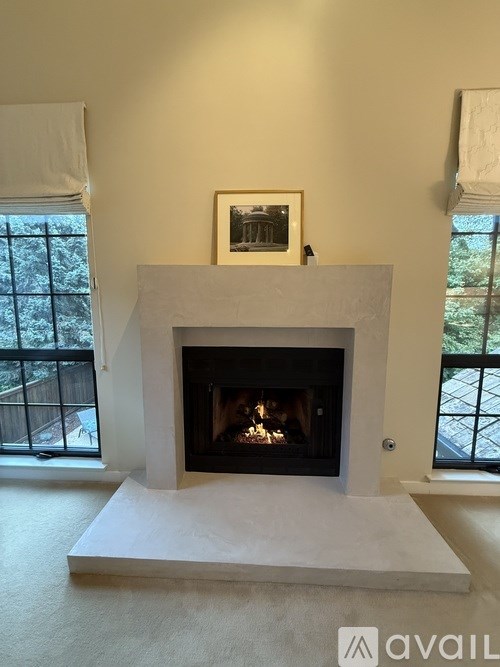 A white fireplace with a picture above it in a room.