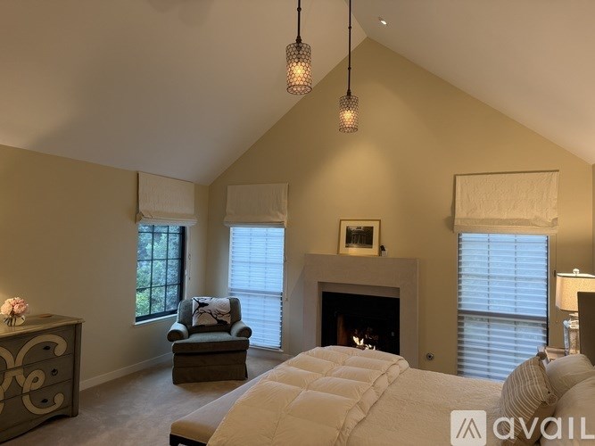 A bedroom with a large bed and a fireplace.