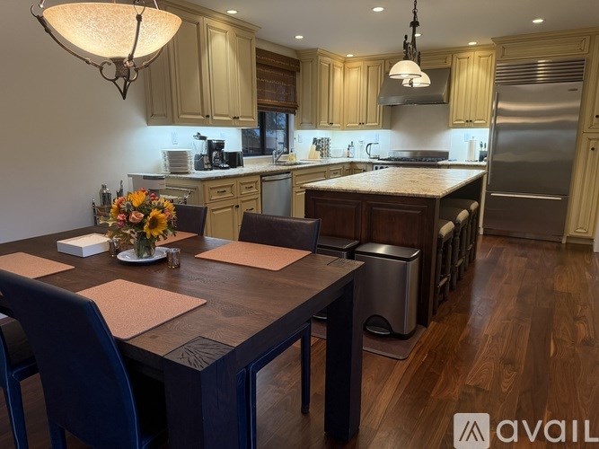 A kitchen with a table set for two and a refrigerator in the background.