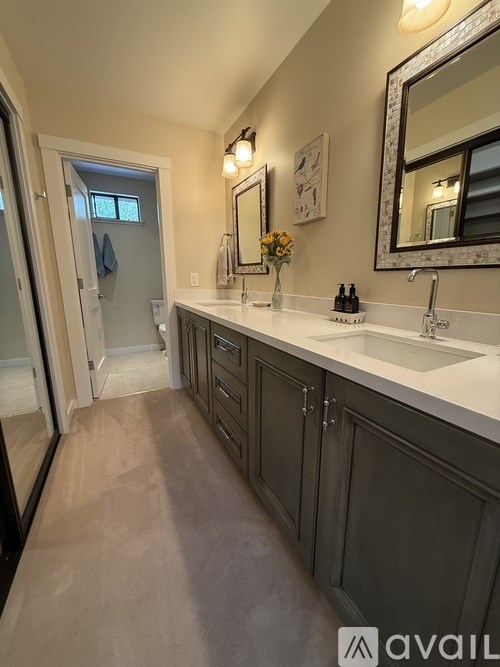 A bathroom with a sink, mirror, and cabinets.