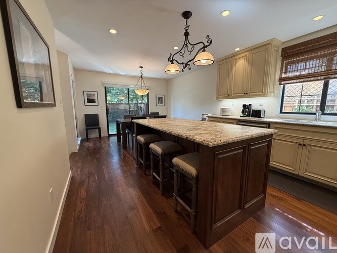 A kitchen with a bar area and wooden floors.