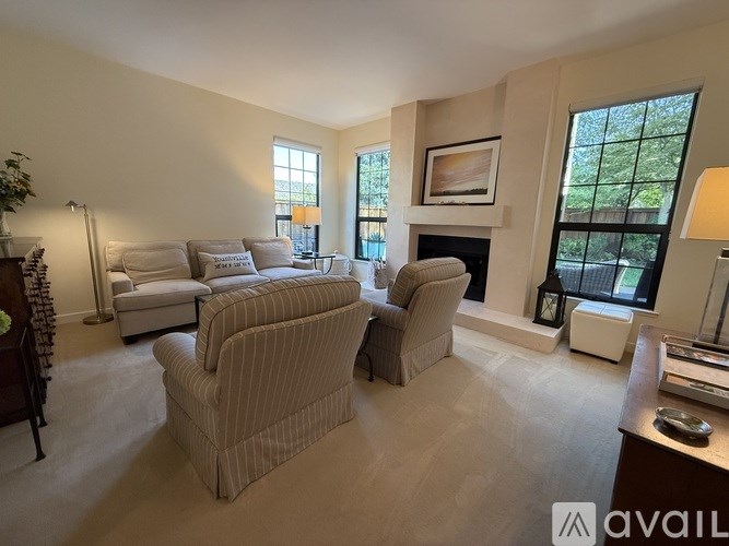 A living room with a fireplace and two striped armchairs.