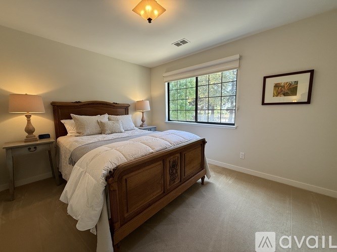 A bedroom with a large bed and a window.