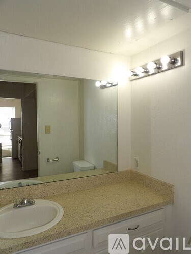A bathroom with a sink, mirror, and lights.