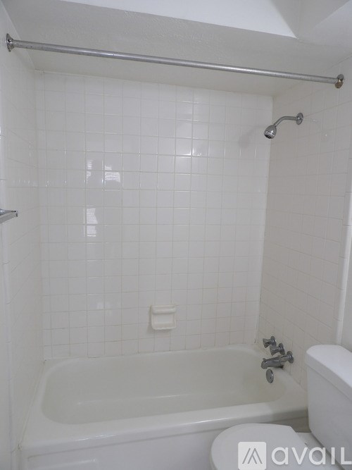 A white bathroom with a tub, toilet and sink.