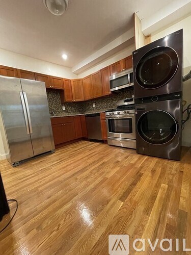 A kitchen with wooden floors and stainless steel appliances.