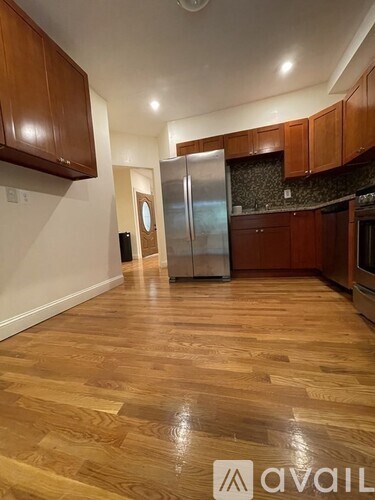 A kitchen with wooden floors and a refrigerator.