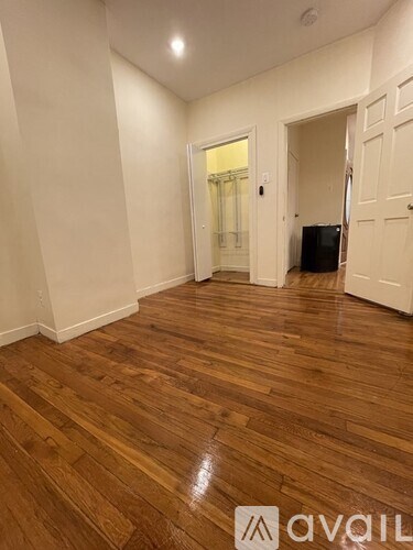 A room with wooden flooring and white walls.