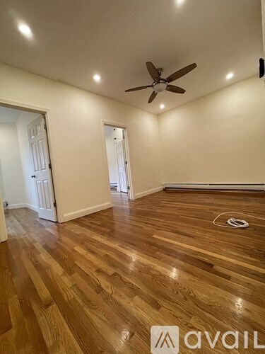 A room with wooden flooring and a ceiling fan.