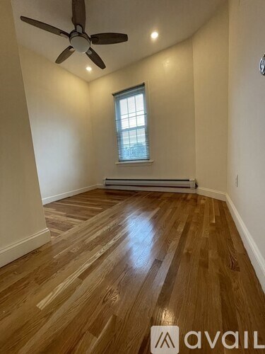 A room with wooden flooring and a ceiling fan.