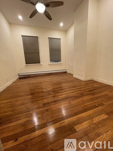 A room with wooden flooring and a ceiling fan.