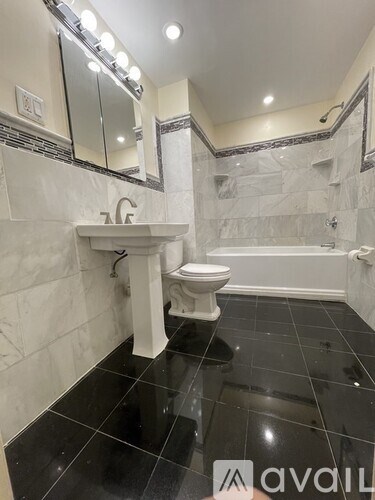 A bathroom with a toilet, sink, and bathtub.