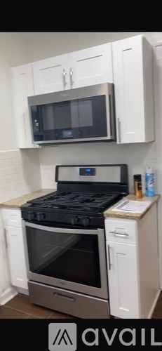 A kitchen with a black stove top oven and white cabinets.