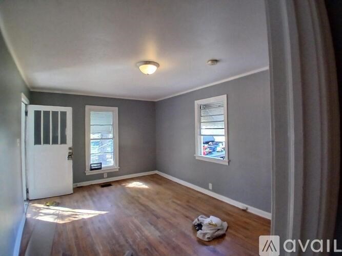 A room with a white door and a window with a view of a street.