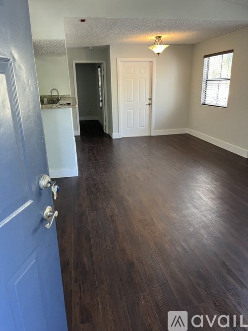 A room with a blue door and wooden flooring.