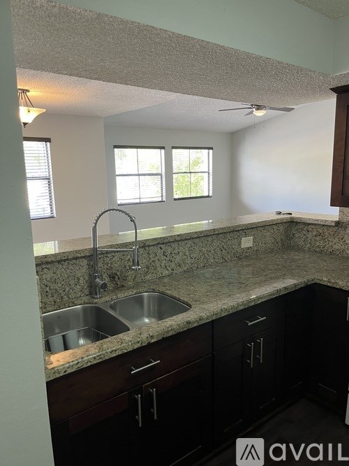 A kitchen with granite countertops and stainless steel sinks.