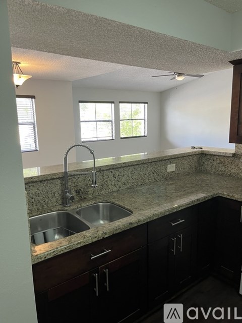 A kitchen with granite countertops and stainless steel sinks.
