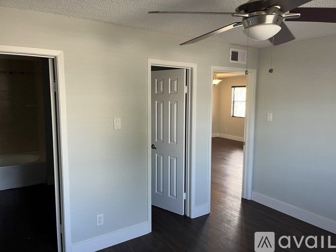A room with a ceiling fan and a door.