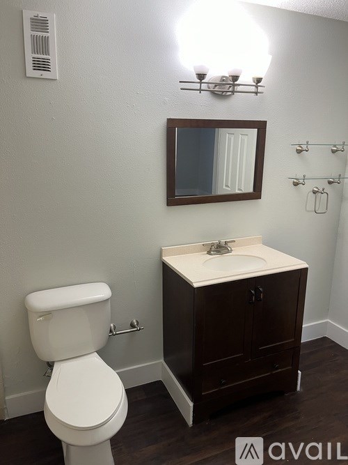A white toilet sits next to a sink in a small bathroom.