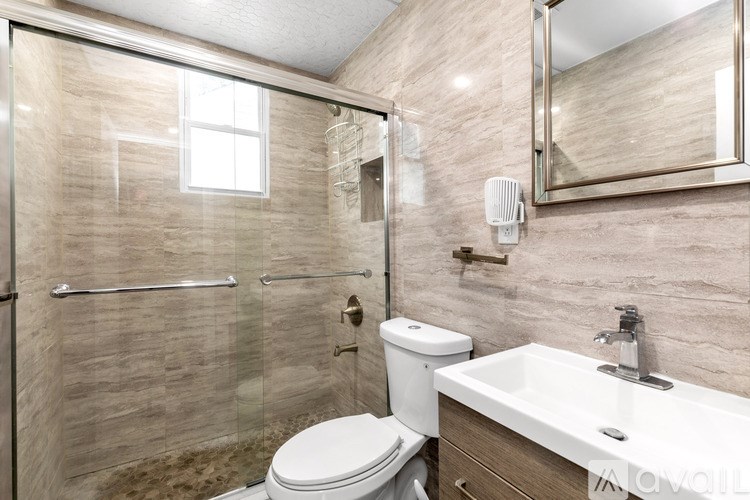A bathroom with a toilet, sink, and shower.