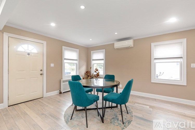 A dining room with a round table and chairs.