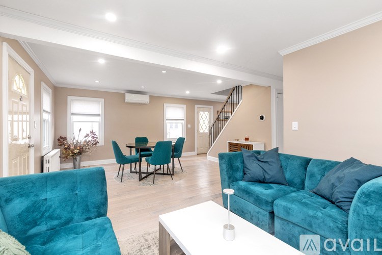 A living room with a blue couch and a dining table.