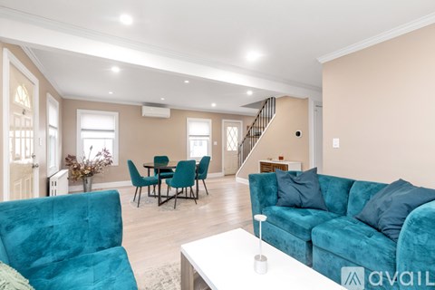 A living room with a blue couch and a dining table.