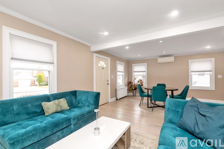 A living room with a blue couch and a white coffee table.