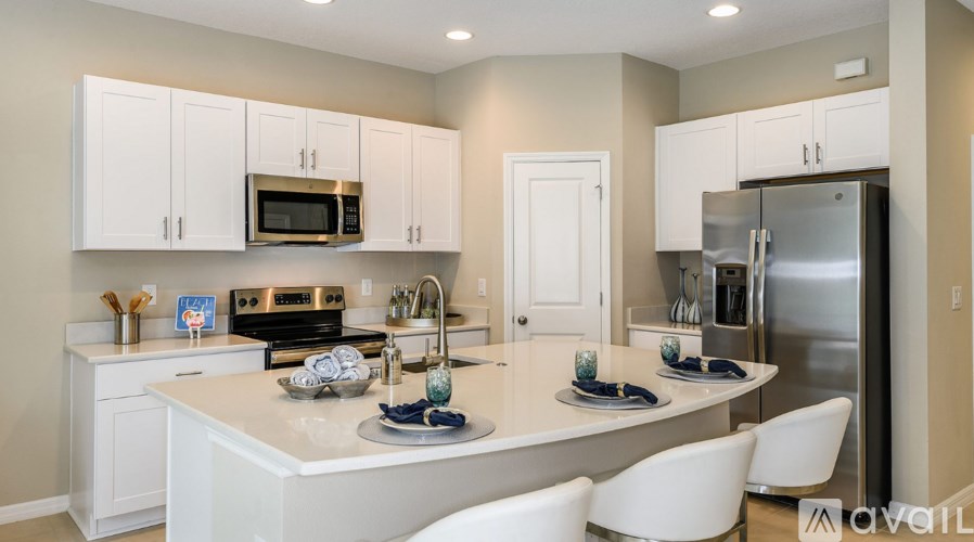 A kitchen with white cabinets and appliances.