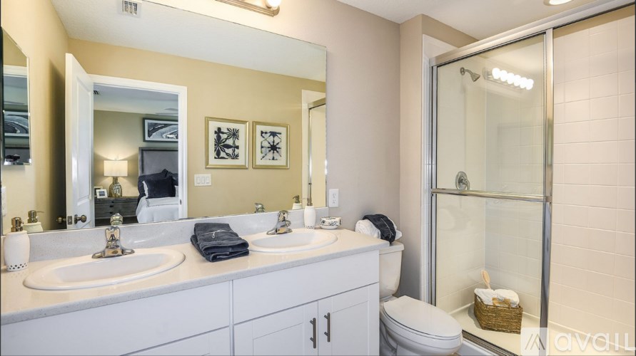 A bathroom with a white countertop and a glass shower door.