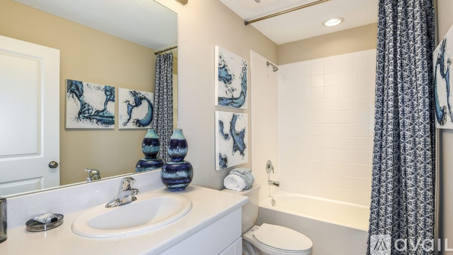 A bathroom with a white sink and a white toilet.