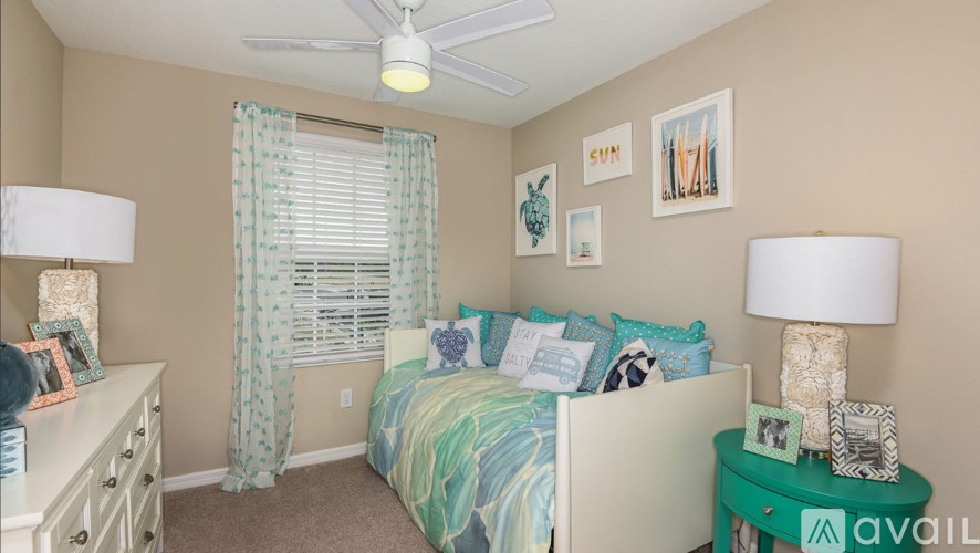 A bedroom with a bed, nightstand, and a ceiling fan.