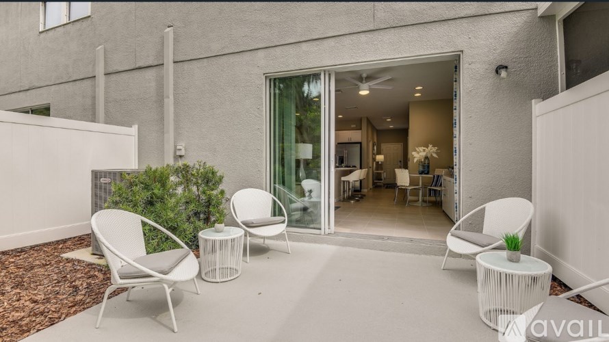 A patio with white chairs and a table is shown.