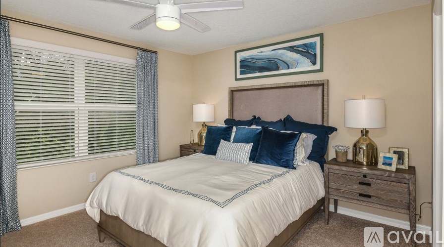 A bedroom with a bed, nightstand, and a ceiling fan.