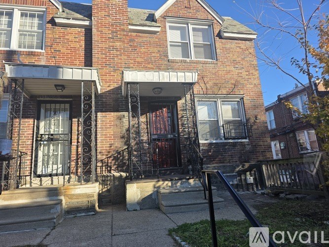 A brick house with a black iron fence in front.