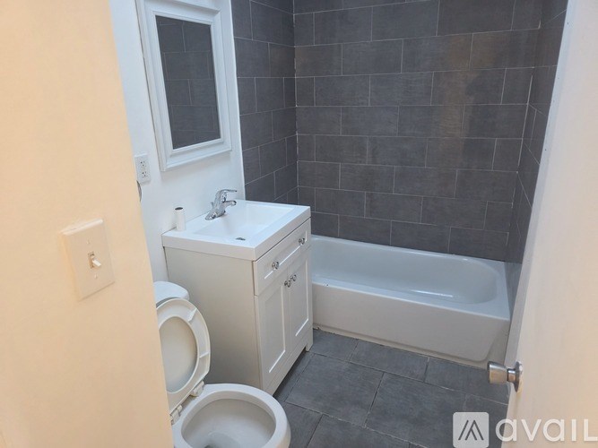 A bathroom with a toilet, sink, and bathtub.