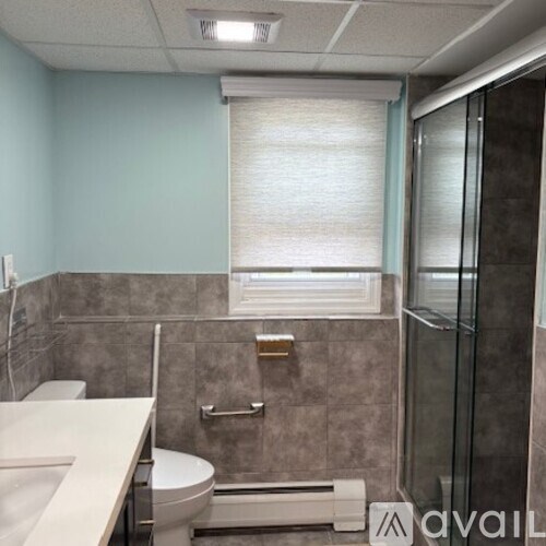 A bathroom with a toilet, sink, and shower.