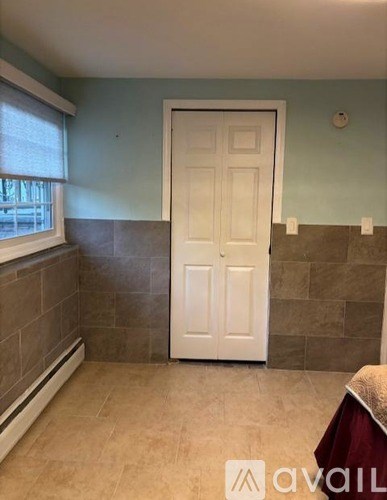 A room with a white door and a window with blinds.