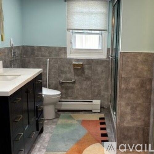 A bathroom with a toilet, sink, and shower.