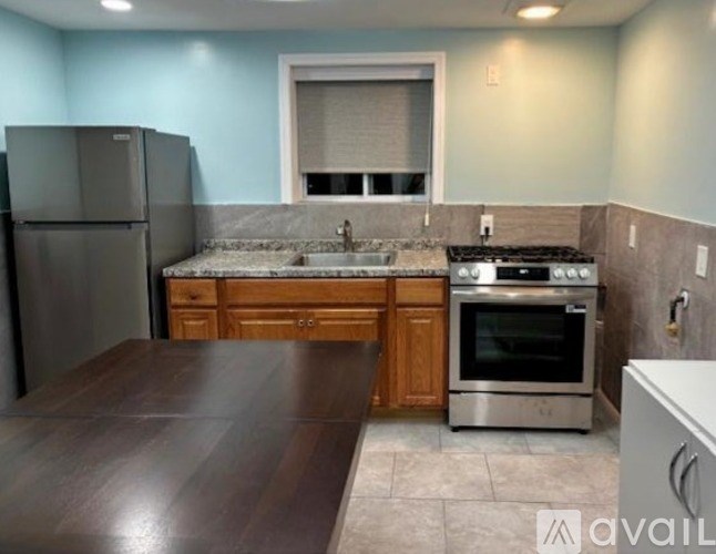 A kitchen with a wooden table and stainless steel appliances.