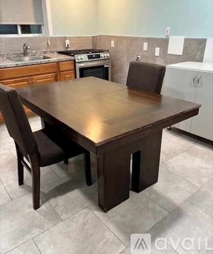 A brown wooden dining table with two chairs in a kitchen.