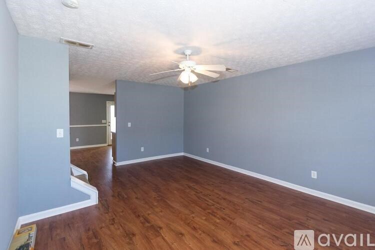 A room with a ceiling fan and wooden flooring.