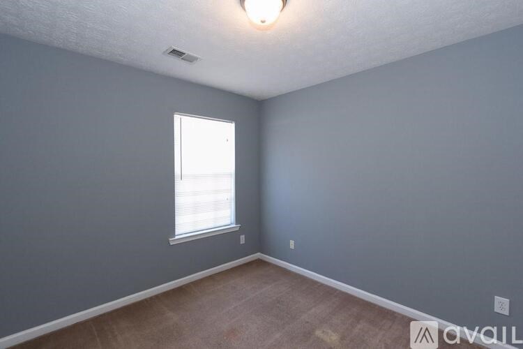 A room with a window and a ceiling light.