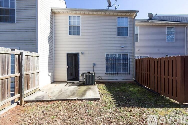 A house with a brown fence and a black door.