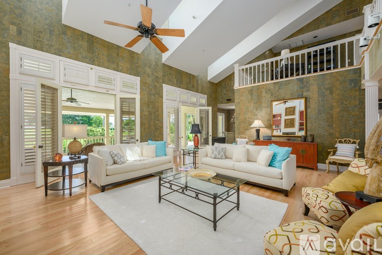 A living room with a white couch and a ceiling fan.